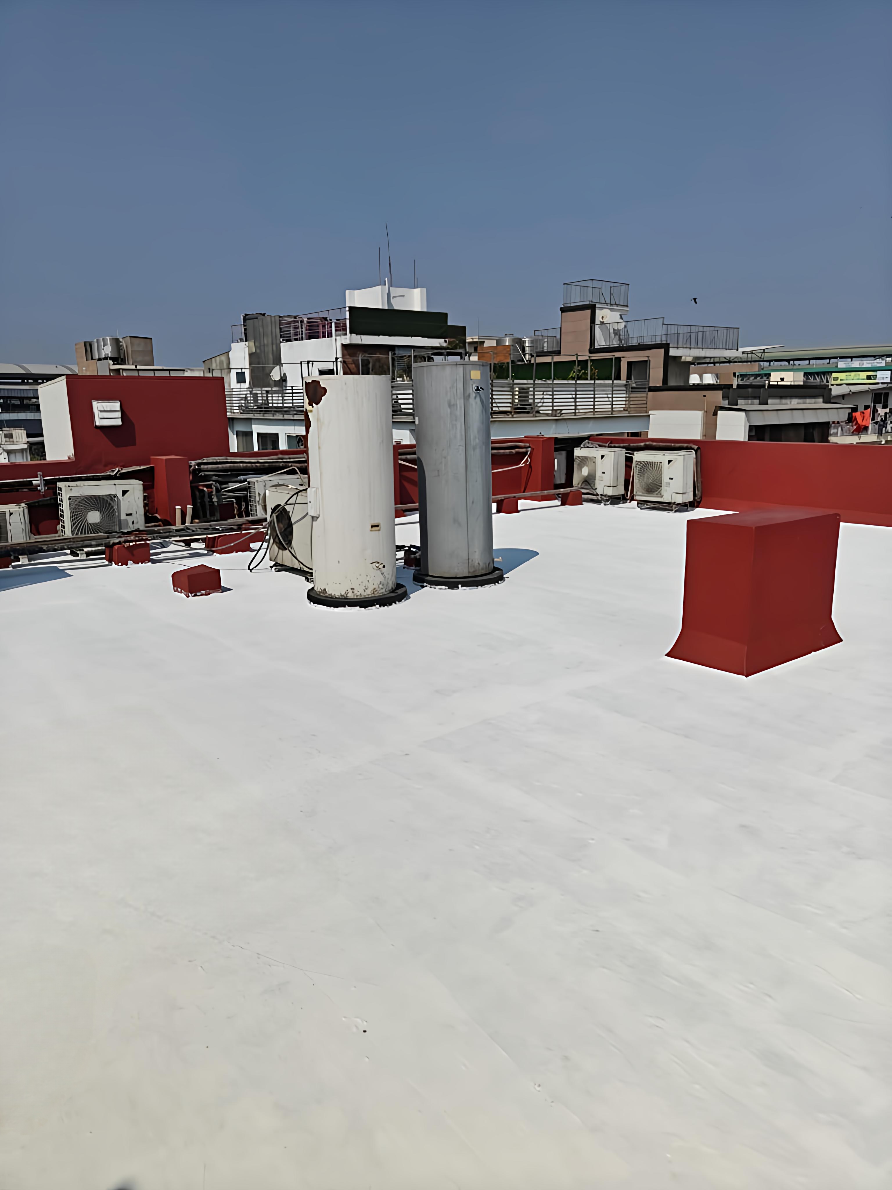 Completed 7-layer waterproofing and heat proofing job in Punjabi Bagh, Delhi — the finished white heat-reflective top coat covering the entire roof plane.