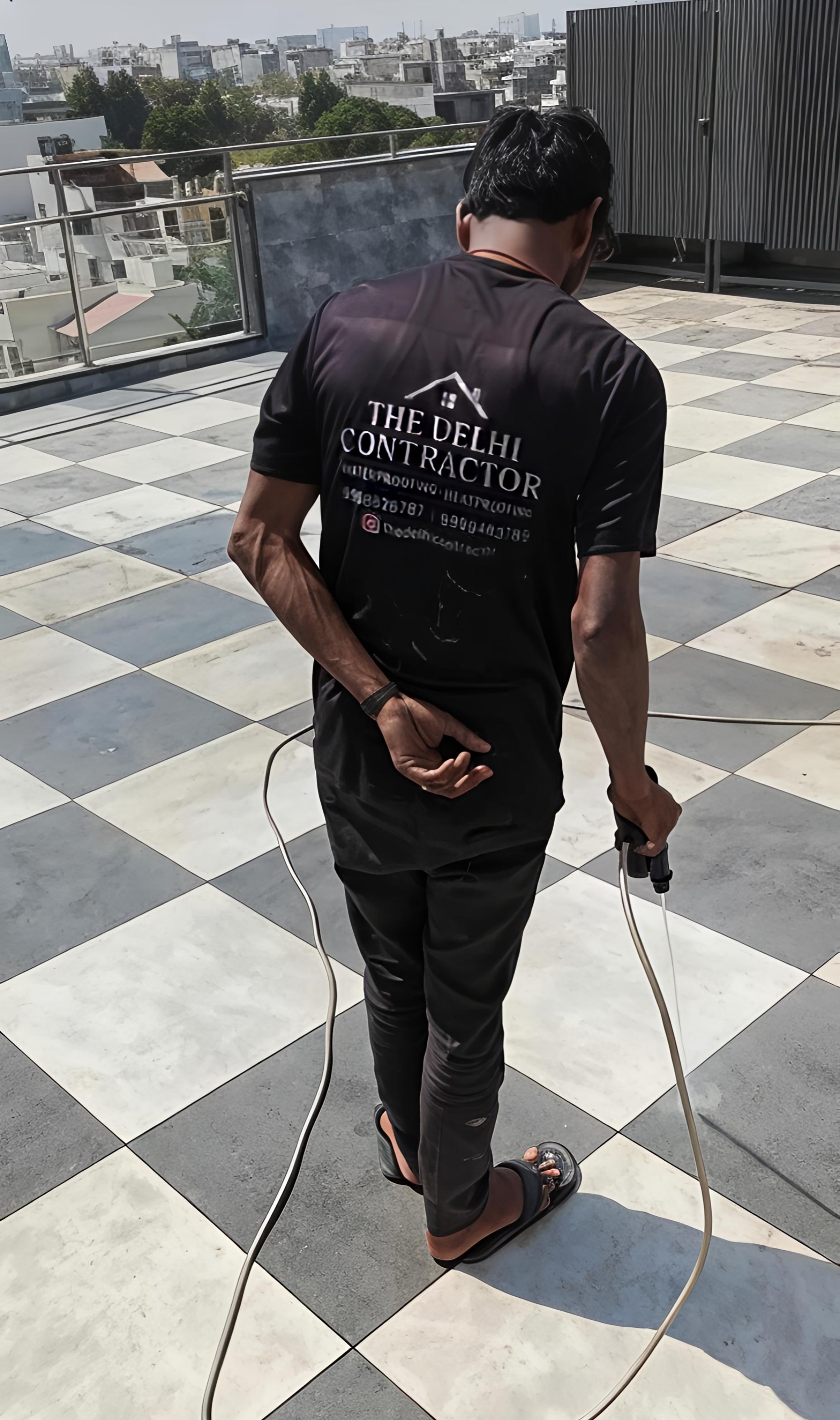 On-site application of transparent 5-layer waterproofing on a terrace in Palam Vihar, Gurgaon, by a uniformed team member.